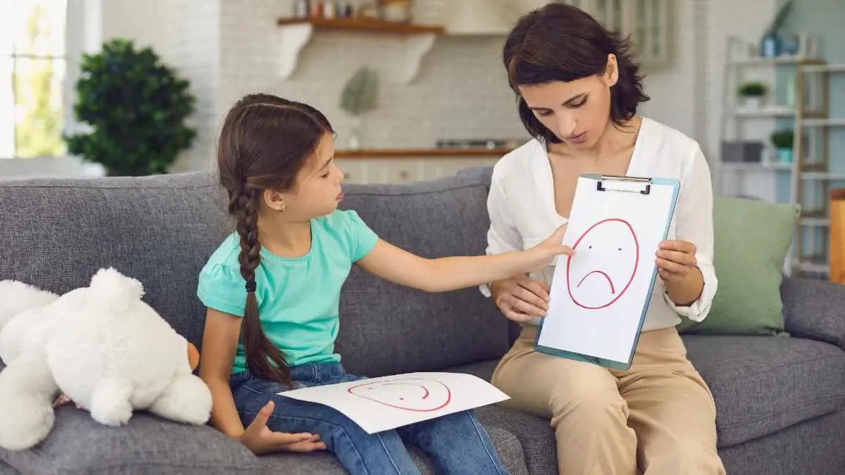Acolhimento e Observação Profissional Psicóloga infantil utiliza desenhos e atividades lúdicas para se conectar com a criança durante a sessão.