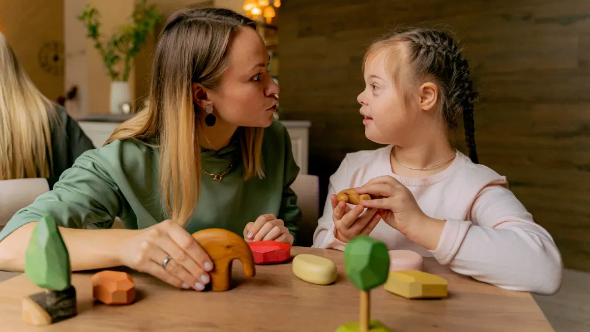 Professora ensinando criança com síndrome de Down - educação inclusiva e atividades pedagógicas adaptadas