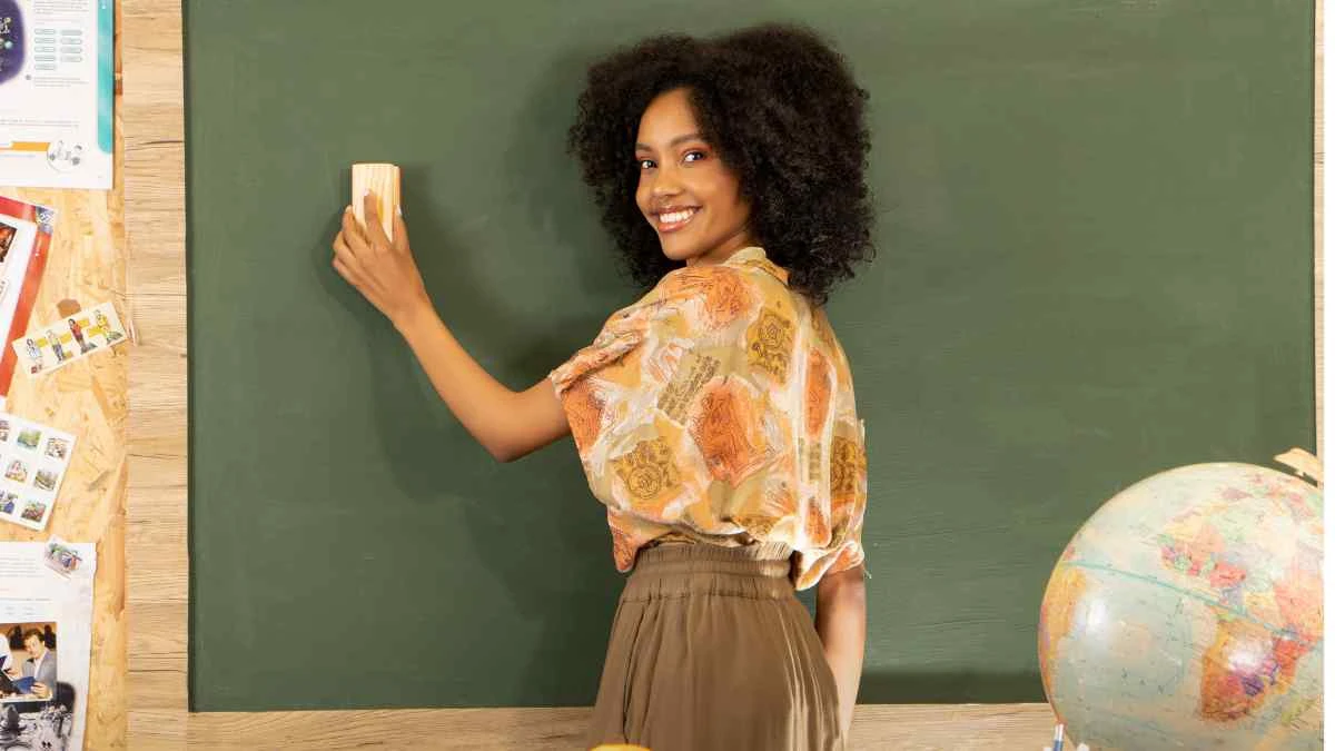 Sala de aula moderna e organizada com recursos educacionais grátis para professores: planos de aula BNCC, atividades pedagógicas de alfabetização e matemática, mapas do Brasil, tabuadas e materiais didáticos diversos espalhados sobre mesa de professor