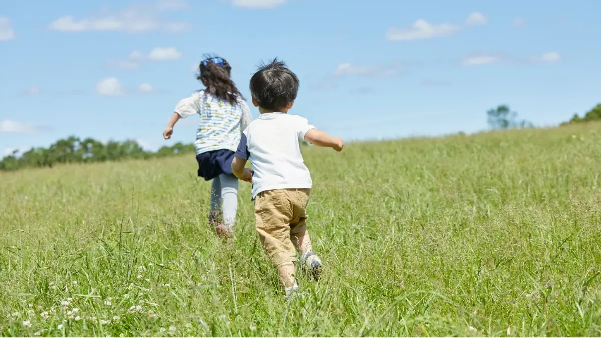 Crianças brincando de pega-pega no pátio da escola, demonstrando alegria e atividade física saudável durante o recreio